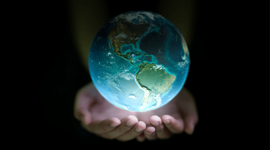 Image of the earth floating in the palm of two hands.